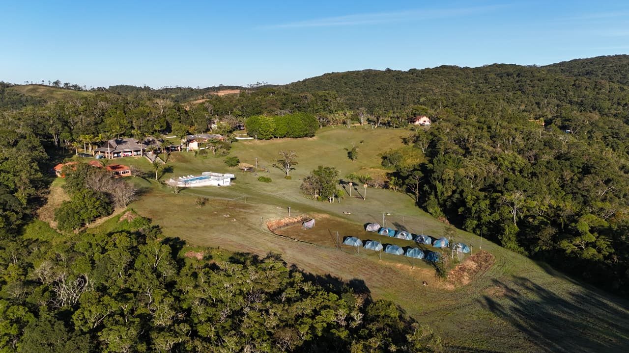 Vista aérea do sítio com área de camping e piscina