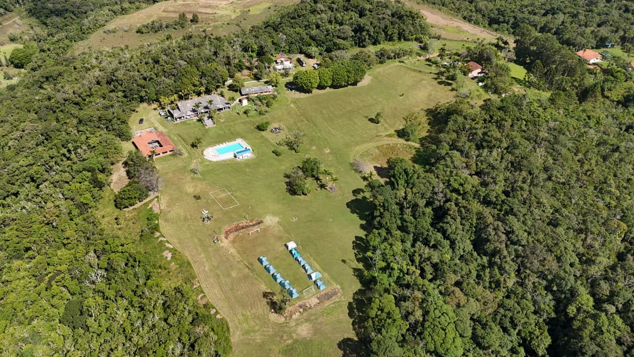 Vista aérea ampla do sítio, campo e áreas gramadas