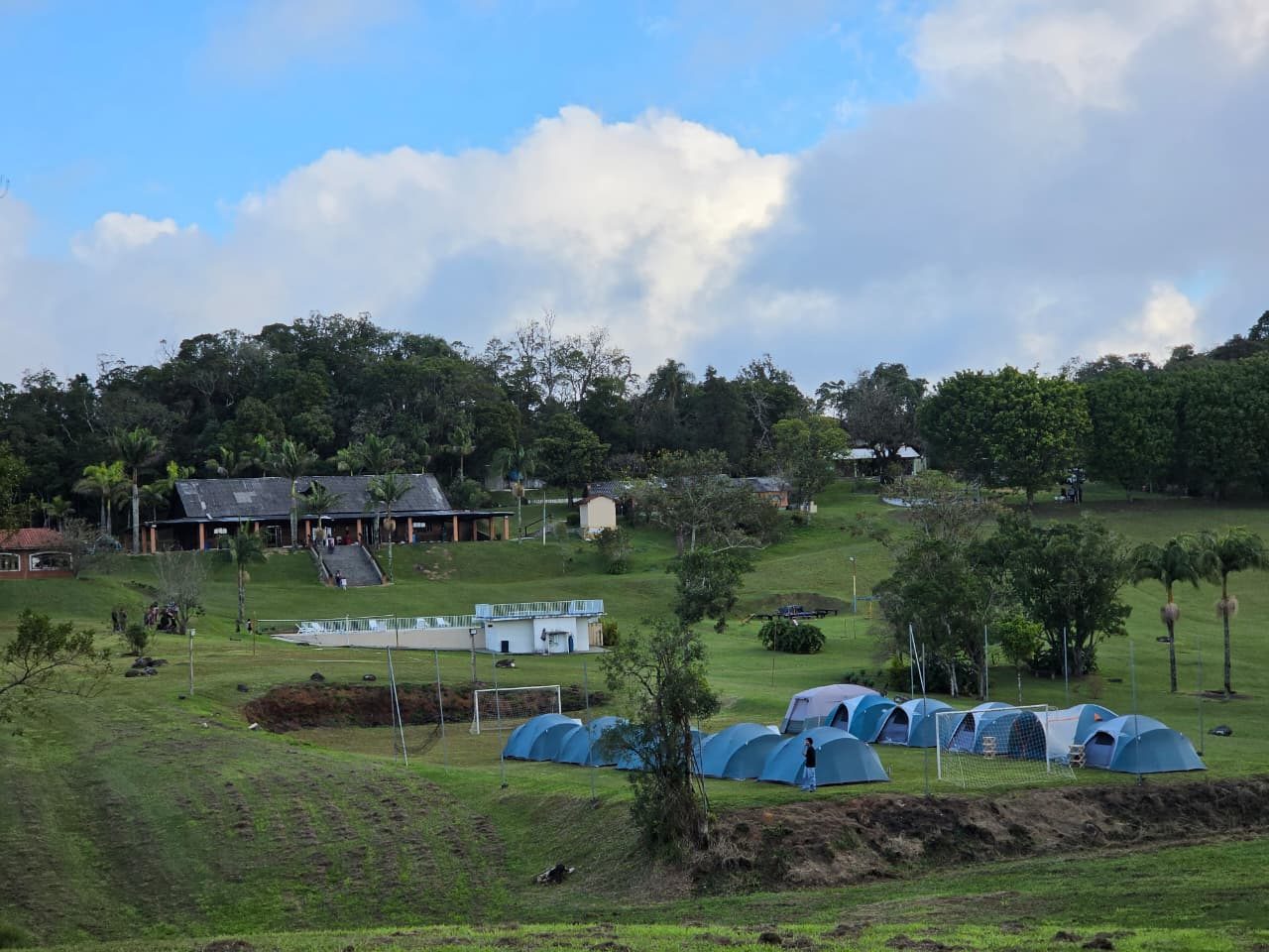 Sítio visto da encosta, com camping e piscina