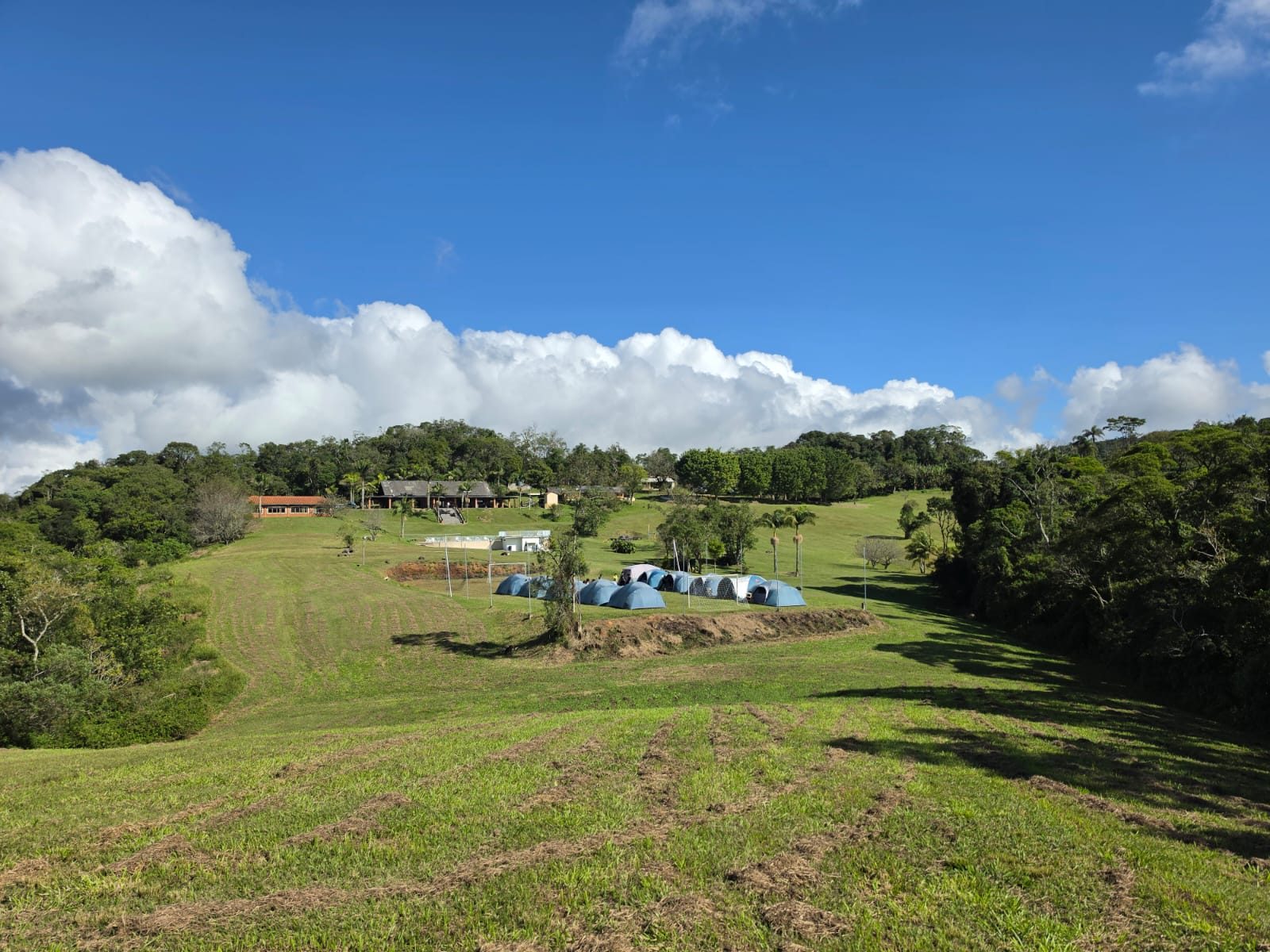 Área de camping no gramado sob o céu azul