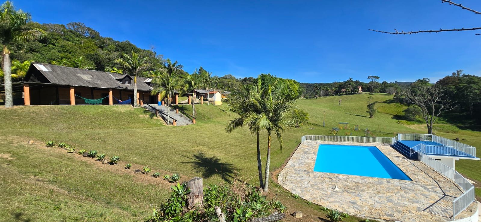 Vista geral do sítio: alojamentos, piscina e gramado