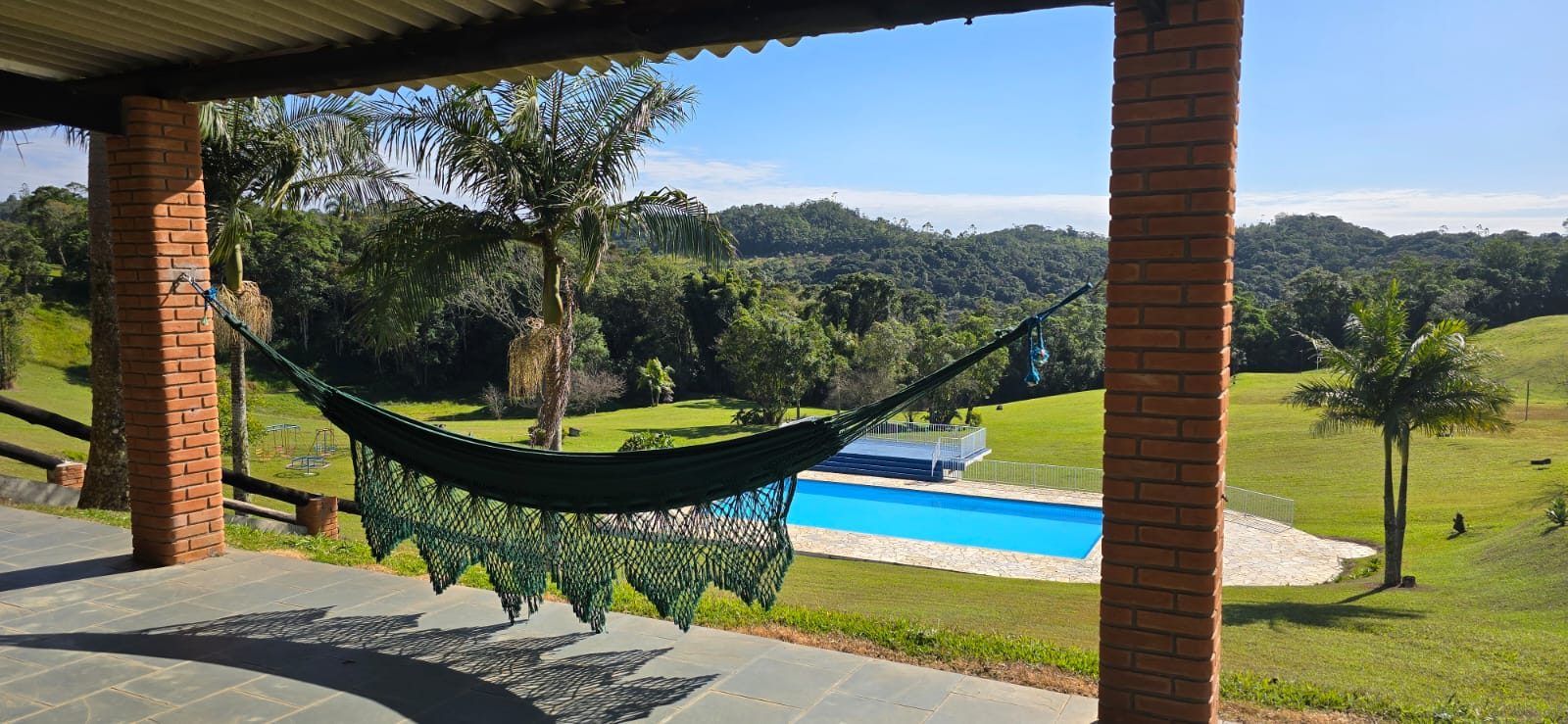Varanda com redário e piscina ao fundo